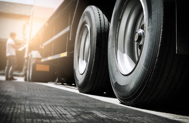 Close up truck tire and truck driver is checking safety around of semi truck.